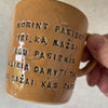 Golden yellow mug with inspirational phrase in Lithuanian